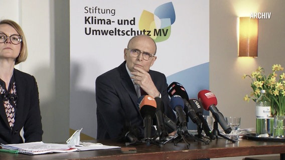 Stiftungsvorstand Erwin Sellering sitzt vor einem Banner der Klimaschutzstiftung. © Screenshot 