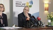 Stiftungsvorstand Erwin Sellering sitzt vor einem Banner der Klimaschutzstiftung. © Screenshot 