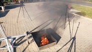 Ein brennendes Objekt bei einer Versuchskonstellation im Freien. © Screenshot 