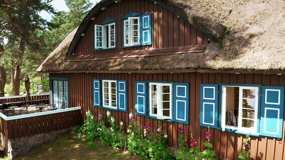 Das Sommerhaus von Thomas Mann in Litauen. Ein Haus im Stile einer Fischerkate aus braunen Holzbrettern. Die Fensterläden und die Ränder des Reetdachs sind blau gestrichen. © Screenshot 