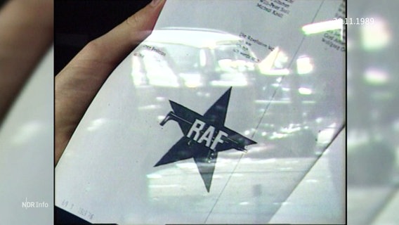 Jemand hät ein Dokument mit dem RAF-Symbol in der Hand. © Screenshot 