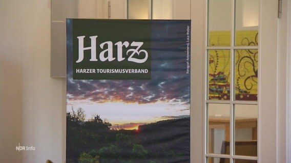Ein Aufsteller des Harzer Tourismusverbands steht vor einer Tür. © Screenshot 
