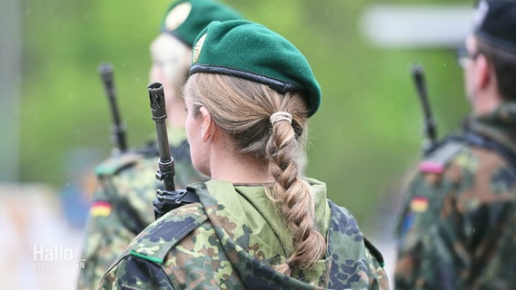 Eine Soldatin mit blondem Zopf und Uniform ist von hinten zu sehen. © Screenshot 