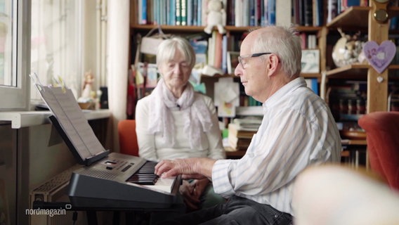 Wolfram Hendrich sitzt am E-Piano, Heidrun schaut ihm zu. © Screenshot 