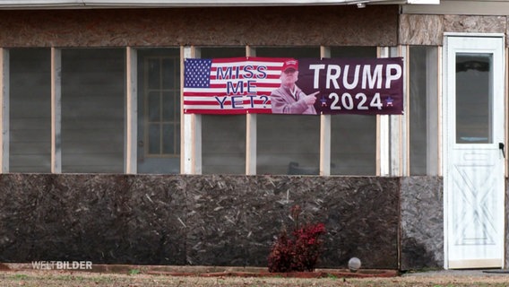 Ein Trump-Plakat hängt an einer Hauswand. © Screenshot 