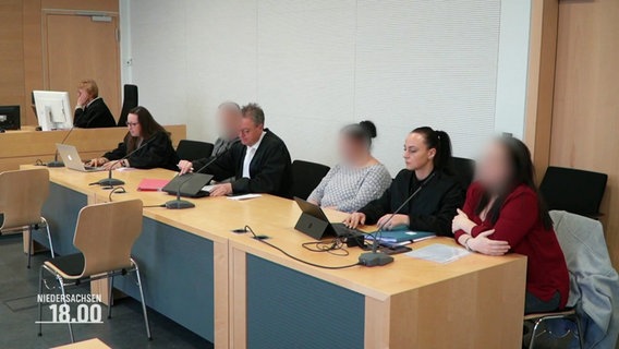Angeklagte in einem Prozess sitzen neben ihren Verteidigern. © Screenshot 