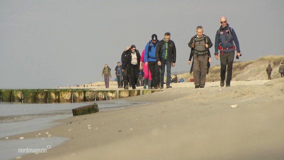 Eine Gruppe Menschen wandert am Meer. © Screenshot 