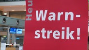 Ein rotes Schild mit der Aufschrift "Warnstreik!" © Screenshot 
