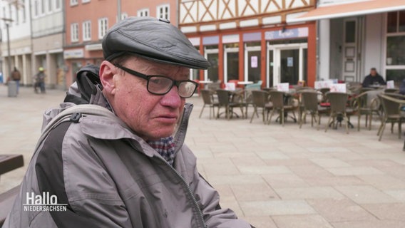 Ralf Bokelmann sitzt auf einer Bank. © Screenshot 