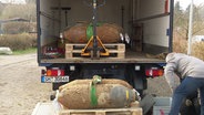 Vier entschräfte amerikanische Fliegerbomben werden in einen Lastwagen verladen. © Screenshot 