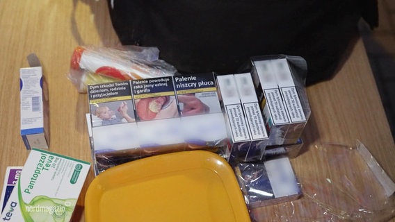 Auf einem Tisch liegen Medikamente und mehrere Packungen Zigaretten aus Polen. © Screenshot 