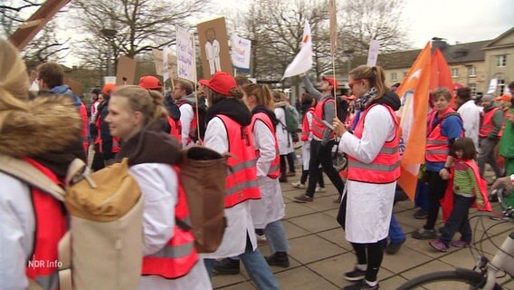 Medizinerinnen und Mediziner streiken in pinken Warnwesten. © Screenshot 