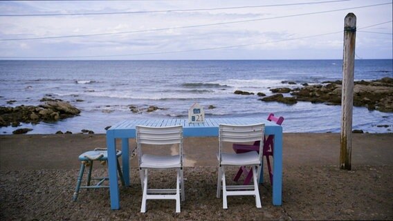 Tisch mit zwei Stühlen am Strand © Screenshot 
