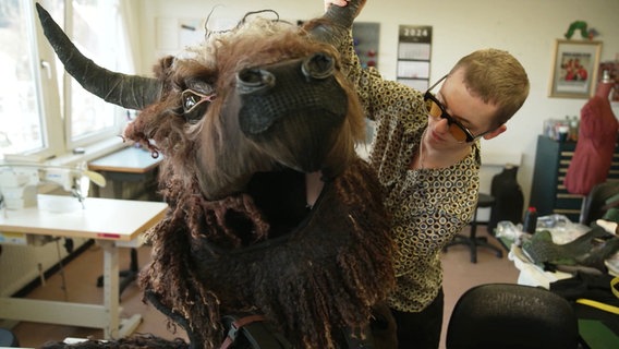 Ein Kostüm mit einem großen Stierkopf wird für die Proben vom Musical "Hercules" vorbereitet. © Screenshot 