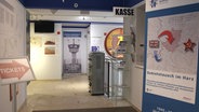 Ein Blick in den Eingangsbereich des Grenzlandmuseums Bad Sachsa mit Kasse, verschiedenen Plakaten und Objekten. © Screenshot 