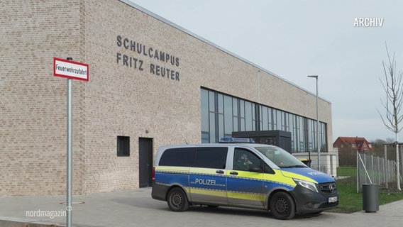 Ein Einsatzfahrzeug der Polizei steht vor einem Schulgebäude. © Screenshot 