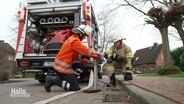 Mitglieder einer Freiwilligen Feuerwehr schließen einen Wasserschlauch an einen Hydranten. © Screenshot 