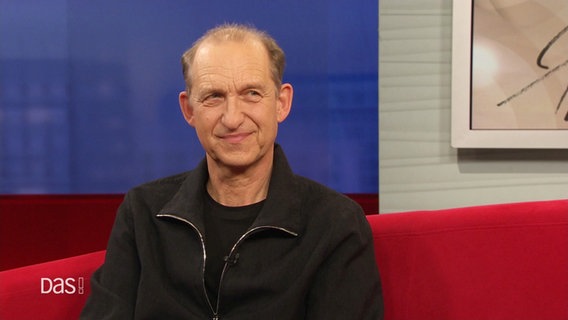 Schauspieler Peter Heinrich Brixm auf dem roten Sofa © Screenshot 