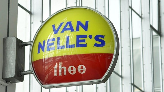 Das Marken-Schild der Van Nelle's thee Fabrik ist an einem Tor angebracht. © Screenshot 