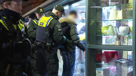 Ein Polizist kontrolliert eine Person am Hamburger Hauptbahnhof. © Screenshot 