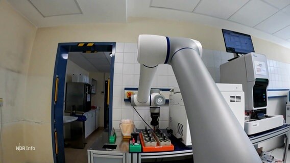 Ein Roboterarm greift eine Probe. © Screenshot 