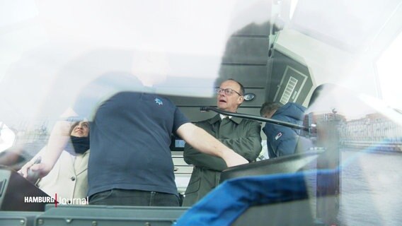 Friedrich Merz steht auf einer Fähre und spricht mit dem Kapitän. © Screenshot 