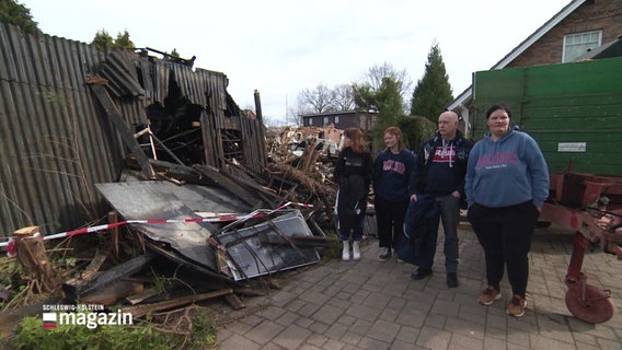 Die Familie steht vor den Trümmern ihres abgebrannten Hauses. © Screenshot 