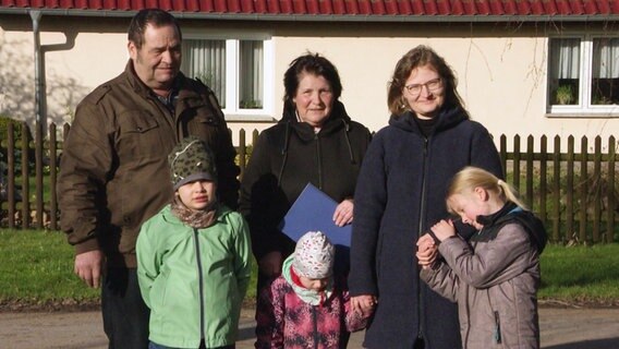Familie Palnau aus Wendisch Baggendorf steht vor einem Wohnhaus. © Screenshot 