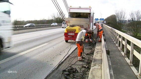 Sanierungsarbeiten auf einer Autobahnbrücke, während der Verkehr weiterrollt. © Screenshot 