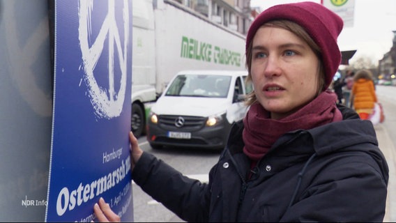 Domenica Winkler neben einem Plakat für den Ostermarsch in Hamburg 2024. © Screenshot 