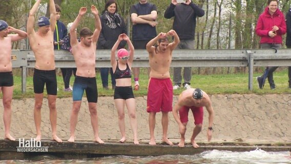 Menschen in Badekleidung springen ins Wasser. © Screenshot 