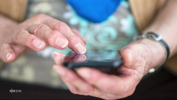 Nahaufnahme einer älteren Person, die ihr Smartphone benutzt. © Screenshot 