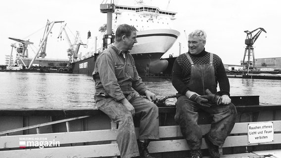 Ein schwarz-weiß Foto zeigt zwei Arbeiter auf einer Lübecker Werft. © Screenshot 