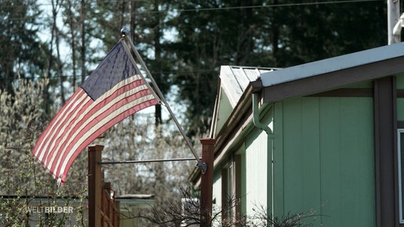 An einem Trailer ist eine amerikanische Flagge befestigt. © Screenshot 