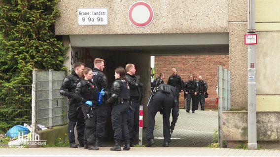 Polizeibeamte stehen vor dem Wohnkomplex Groner Landstraße 9. © Screenshot 