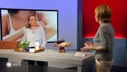 Dr. Julia Maerker-Strömer und Moderatorin Vera Cordes im Studio. Auf einem Tisch stehen diverse Cremes, Tücher und Pflanzen. © Screenshot 