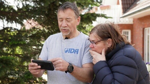 Ein Mann zeigt einer Frau ein Foto auf seinem Smartphone. © Screenshot 