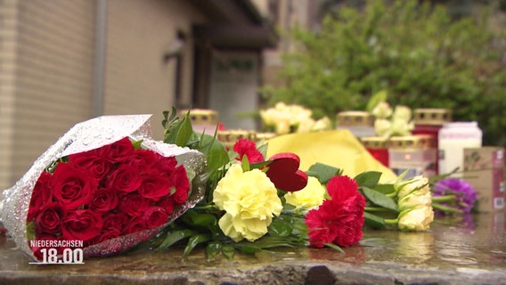 Blumensträuße und Kerzen vor einem Haus in Nienburg © Screenshot 