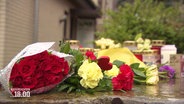 Blumensträuße und Kerzen vor einem Haus in Nienburg © Screenshot 