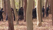 Polizisten durchsuchen den Wald nach dem Gesuchten. © Screenshot 