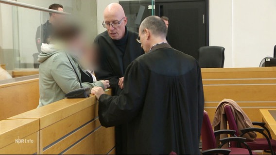 In einem Gerichtssaal unterhalten sich drei Personen. © Screenshot 