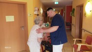 Ein Pfleger hat ein offenes Ohr für das Anliegen einer Seniorin. © Screenshot 