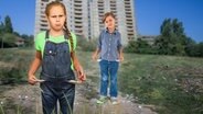 Zwei Kinder mit leeren Hosentaschen vor einem Wohnblock. (extra 3 vom 11.04.2024 im Ersten) © NDR 
