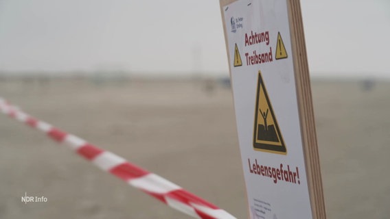 Ein Schild und Absperrband warnen vor Treibsand. © Screenshot 