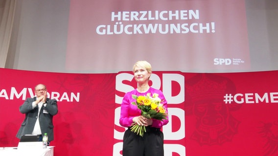 Manuela Schwesig mit einem Blumenstrauß in der Hand. © Screenshot 