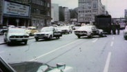 Alte Videoaufnahmen von 1974. Polizeiauto stehen ungeordnet auf einer Straße am Steindamm, einige Autotüren sind geöffnet. © Screenshot 