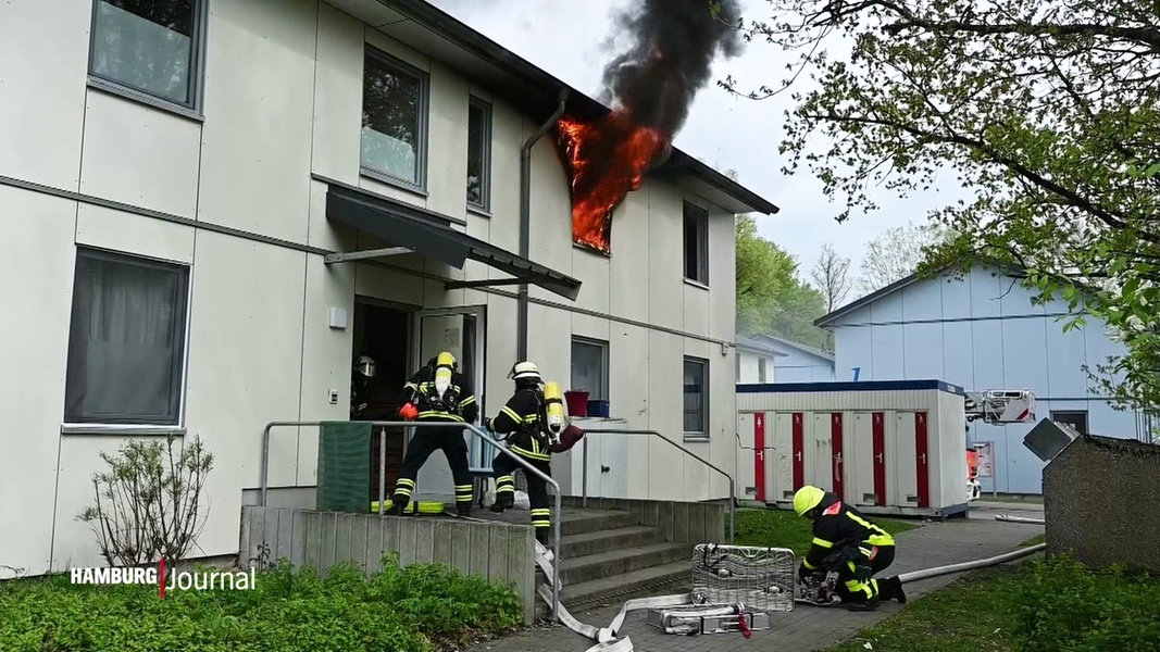 Feuerwehrleute versuchen einen Brand in einer Flüchtlingsunterkunft in Rahlstedt zu löschen.