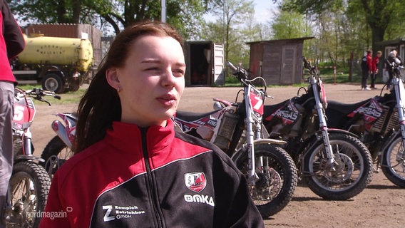 Amy-Luisa Behrend, im Hintergrund mehrere Motorräder. © Screenshot 