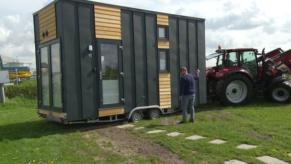 Ein Trekker transportiert ein Tiny House an seinen Standort. © Screenshot 