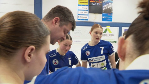 Handballtrainer gibt seinen Spielerinnen Anweisungen. © Screenshot 